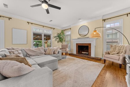 Bright living room with cozy fireplace, modern decor, large windows, and elegant furniture showcased by John Langevin.