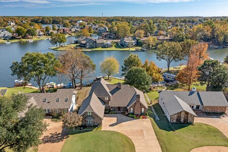 Beautiful aerial view of Houston lakefront properties with lush greenery and water access.