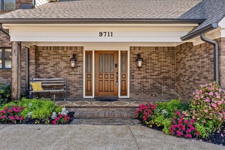 Friendly front porch with vibrant flowers and outdoor seating.