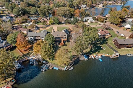 Scenic aerial view of lakeside homes with private docks and boats.