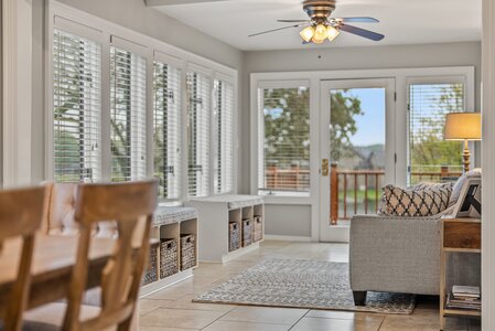 Bright sunroom featuring large windows, comfortable seating, and scenic outdoor views, perfect for relaxation.