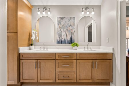 Double sink bathroom vanity with wooden cabinets and elegant mirrors, perfect for a contemporary home decor.