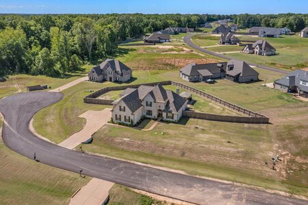 Beautiful aerial view of a large, modern family home with landscaped yard.