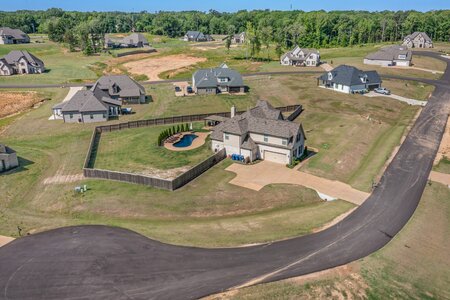 Aerial view of a beautiful house with a backyard pool in a new residential neighborhood.