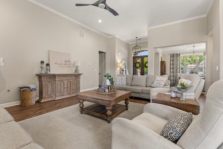Bright, spacious living room blending modern comfort with farmhouse chic, featuring neutral tones and stylish accents.