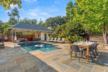 Poolside oasis with outdoor seating and dining space for relaxing and entertaining.