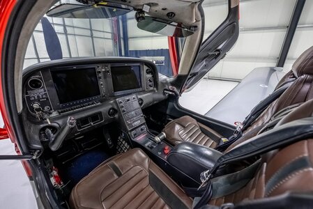 Helicopter cockpit with modern avionics and leather seating, showcasing pilot controls.