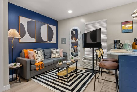 Chic living space featuring a blue wall, abstract art, and contemporary furnishings.