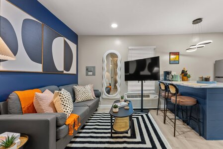 Bright, cozy living space featuring bold wall art, decorative pillows, and contemporary furnishings.