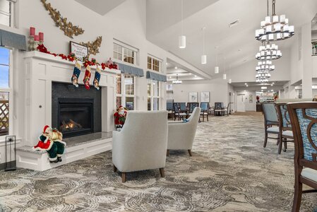 Comfortable hotel lounge area with holiday décor, fireplace, and seating, perfect for enjoying festive seasons and holiday celebrations.