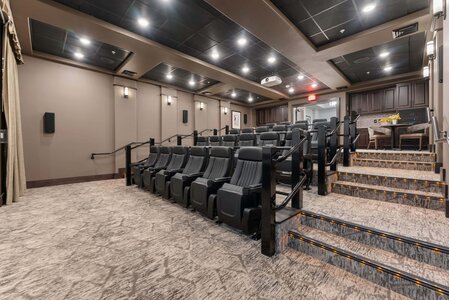Luxury home theater with tiered seating and surround sound system.