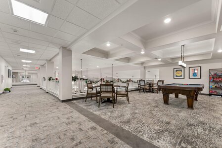 Spacious hotel lounge featuring pool table, cozy seating, and modern decor for guest enjoyment.