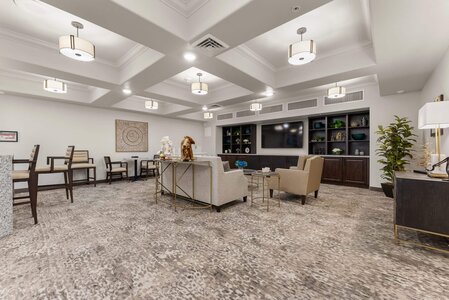 Bright, modern hotel lobby with comfortable seating, stylish decor, and a large TV for guest relaxation.