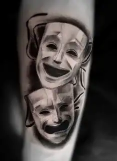 Tatuajes 19 Tatuaje realista de las clásicas máscaras de comedia y tragedia, con un sombreado dramático que resalta el contraste entre ambas emociones.