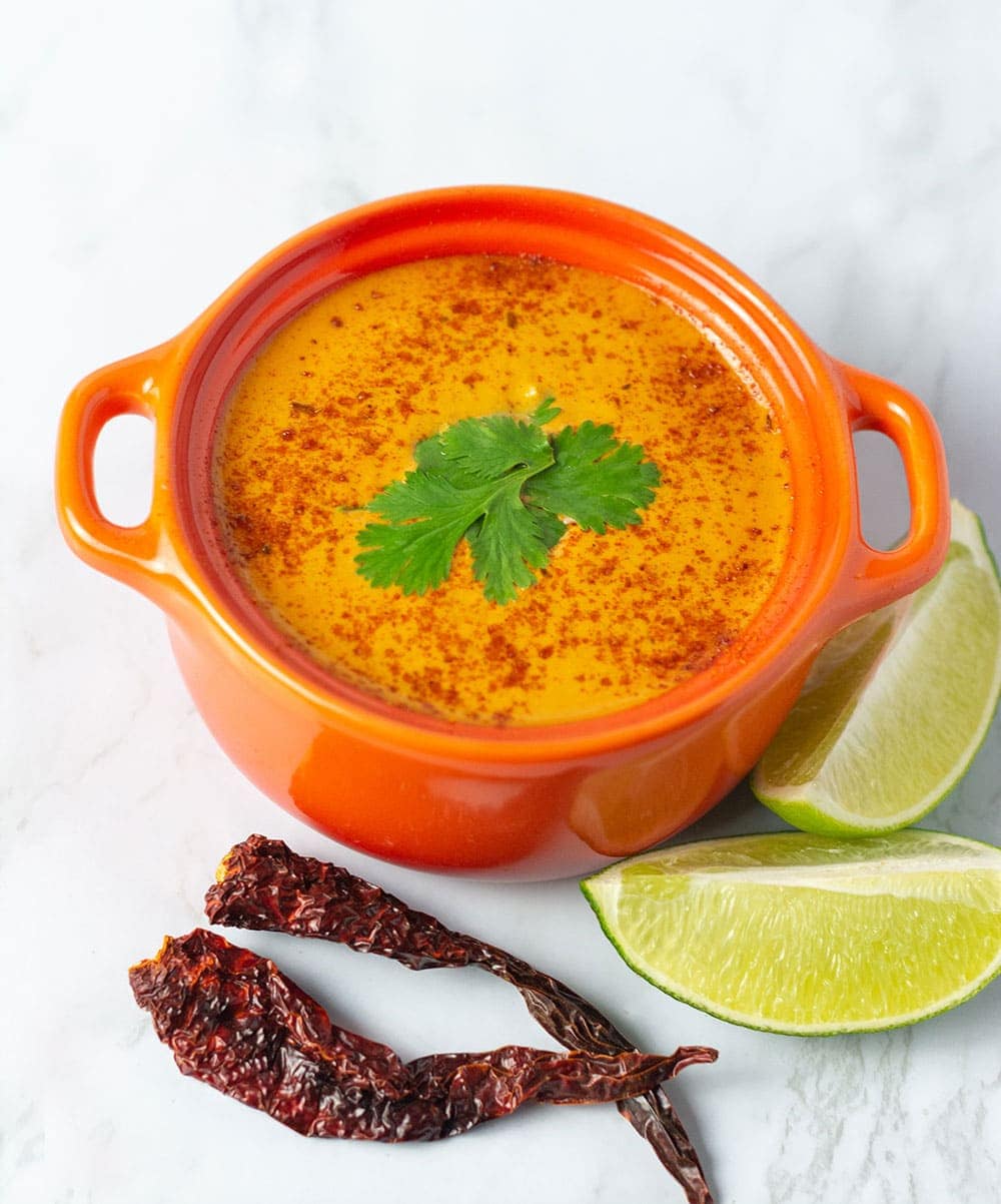chipotle lime crema in an orange bowl, garnished with cilantro leaves and paprika