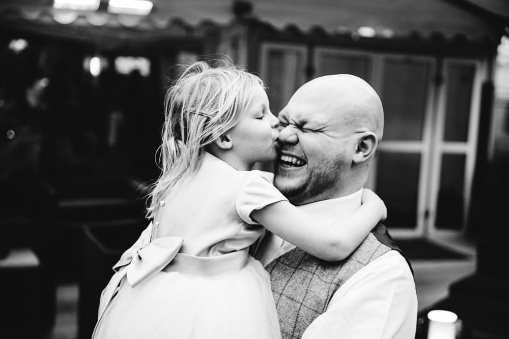 little girl kissing daddy at a wedding