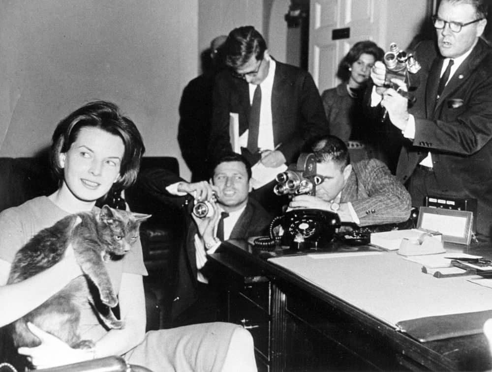 First Lady Jacqueline Kennedy's Press Secretary Pamela Turnure sits in an office holding Caroline Kennedy's cat, Tom Kitten, 24 January, 1961. Photo: Abbie Rowe. White House Photographs. John F. Kennedy Presidential Library and Museum, Boston, public domain.