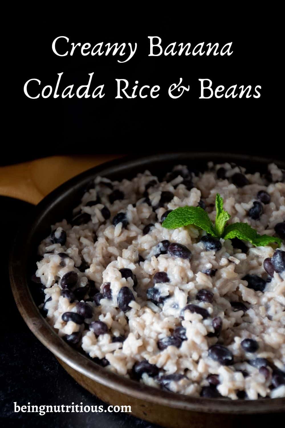 Pinterest image of Banana coconut rice and black beans on a round metal plate, garnished with mint, on a dark background.