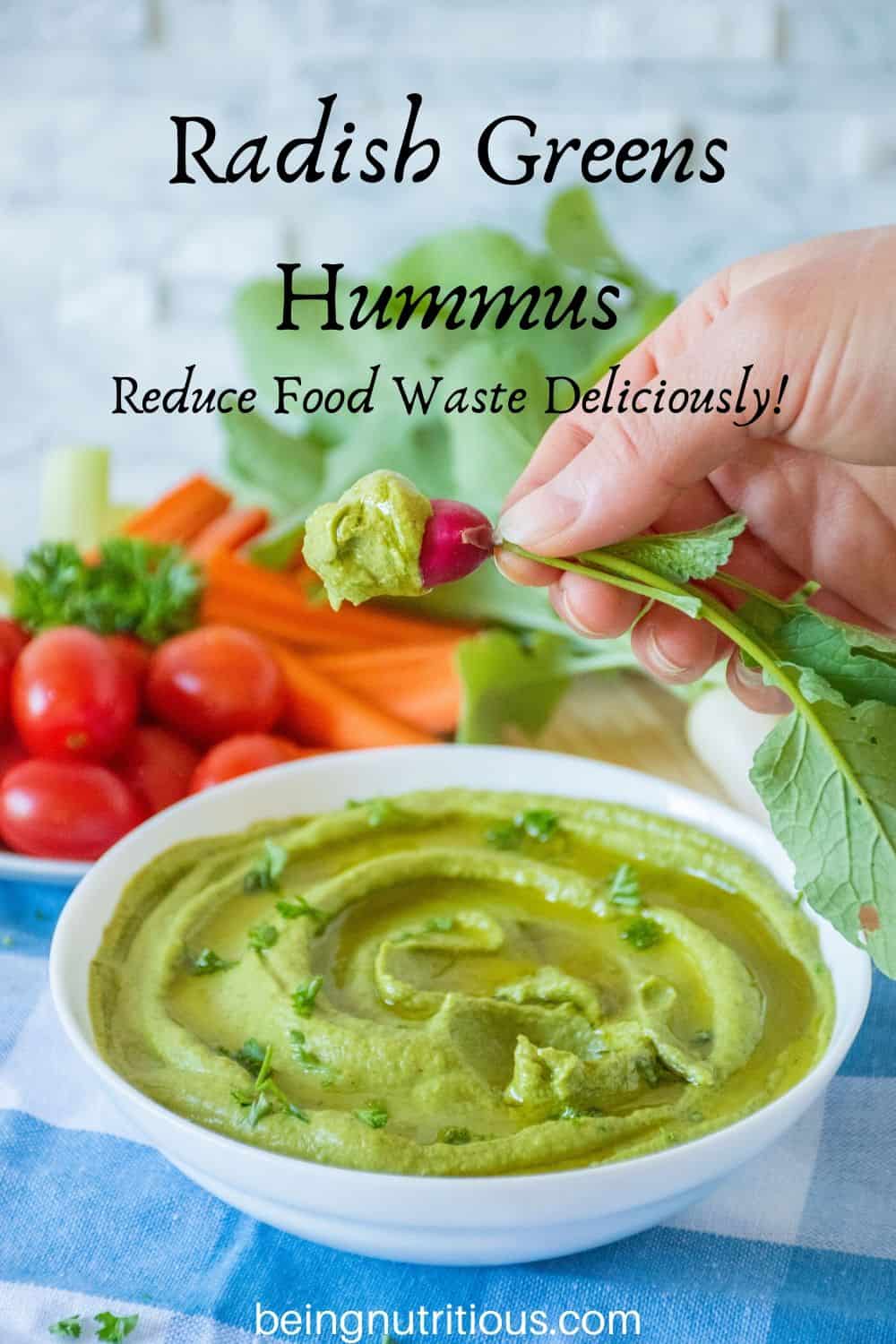 Radish Greens Hummus in a bowl with a hand dipping a radish in it.