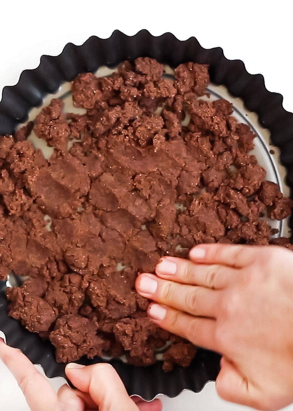 Hand smoothing pie crust into pan