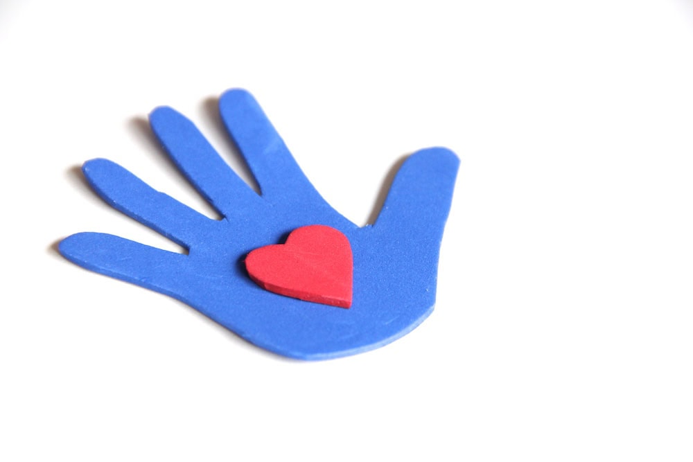 Photo of a blue hand-shape cut from craft foam with a red foam heart on top.