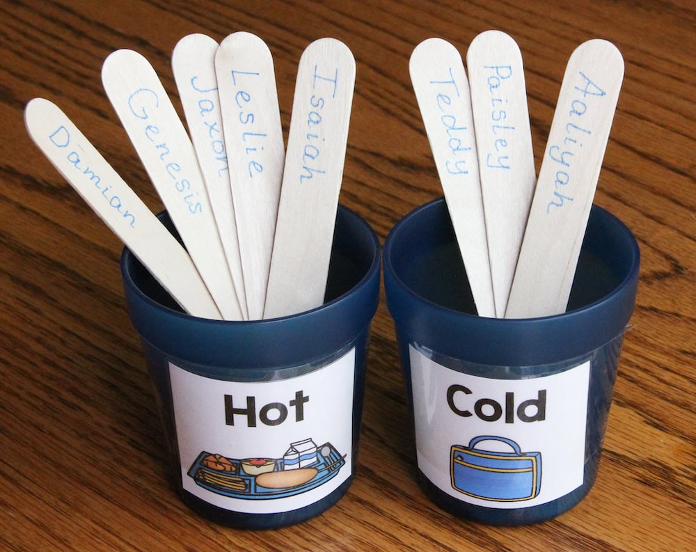 Photo of two blue cups, labeled "Hot" and "Cold." Student name sticks are placed in the cups to indicate lunch choices.