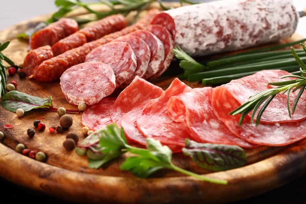All kinds of meat, smoked sausage, salami on a platter, camping food without a fire