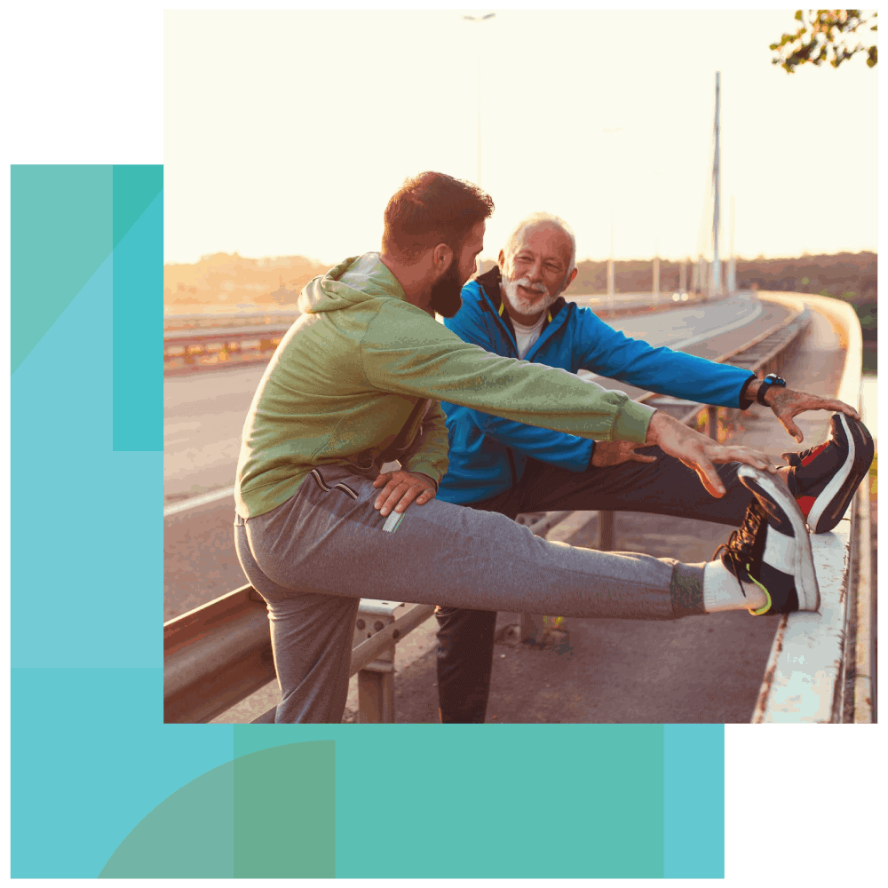Two men talk and stretch after running in a city suburb An elderly man and a young man talk and stretch after running in a city suburb.