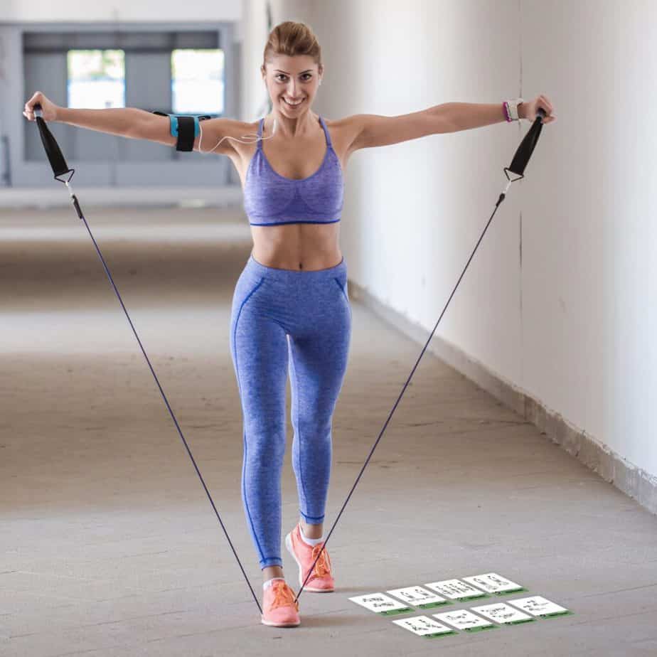 A girl has a training with resistance bands at the gym