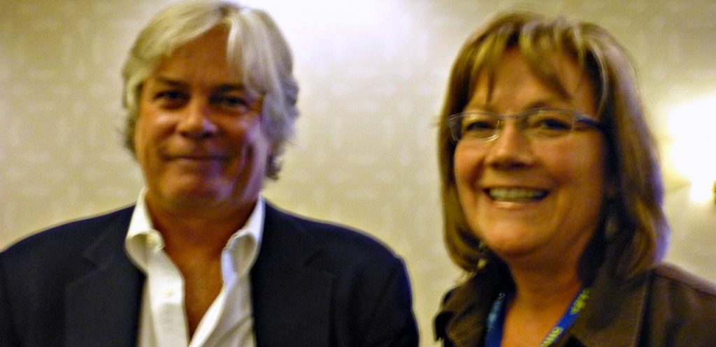 Man is unbuttoned white shirt and blue blazer stands with Arizona travel writer Stacey Wittig