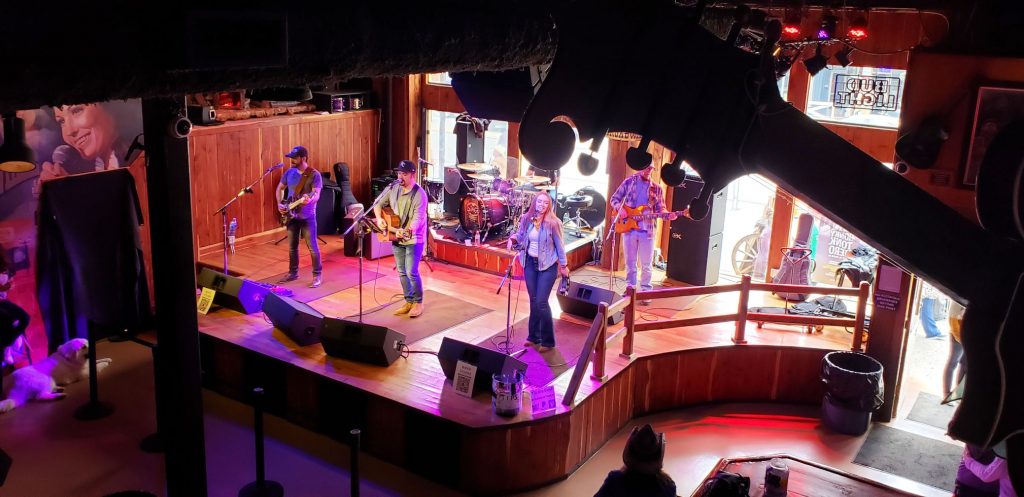band with woman singer, two guitarists and drummer taken from 2nd floor -social distanced for Nashville safety