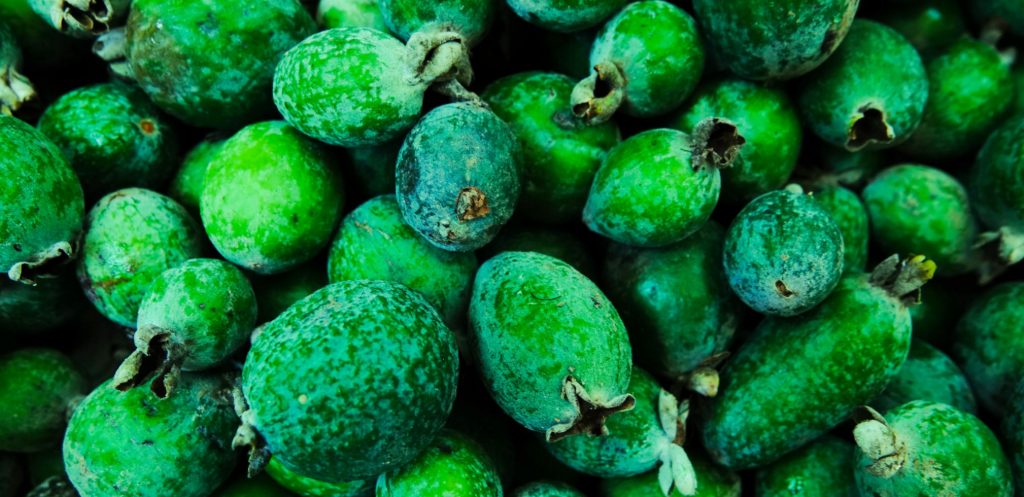 Green fruit packed into a market bin - close up of the exotic fruit