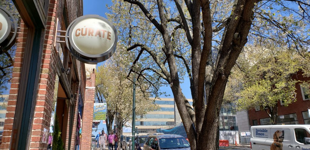 Outside of Curate restaurant in Asheville, NC with sign on red brick wall