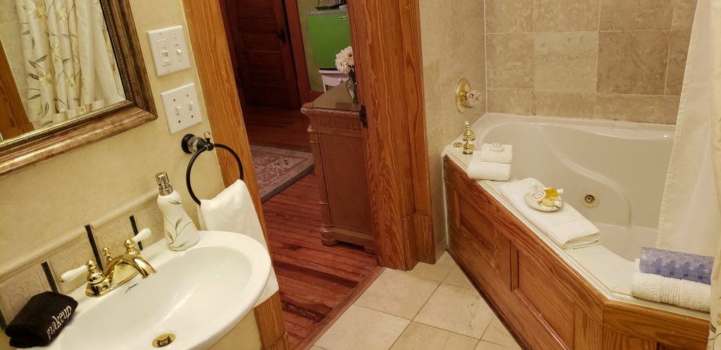Bathroom with 12-inch tile floors, Jacuzzi bathtub for two and sink at Cumberland Falls Bed and Breakfast