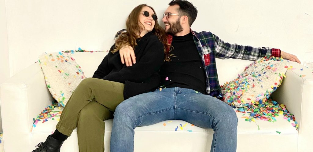 Happy young couple stretch out on couch at home