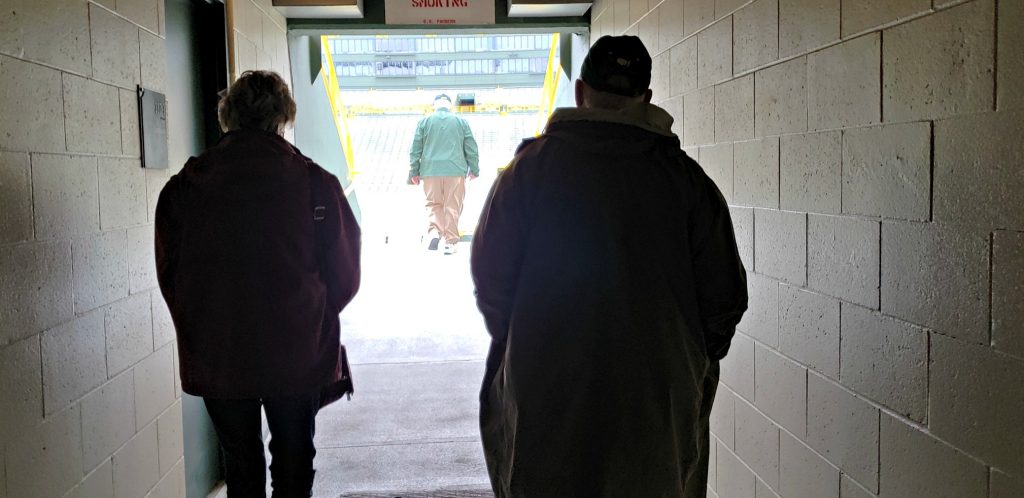 silhouettes of man and women tourists going into stadium from dark hallway 1. Lambeau Field Green Bay Wisconsin Tops the List of Things to See In Green Bay