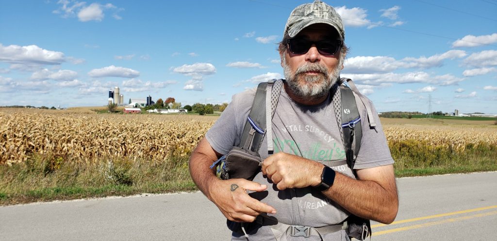 bearded man with sunglasses looks at camera on the Wisconsin pilgrimage