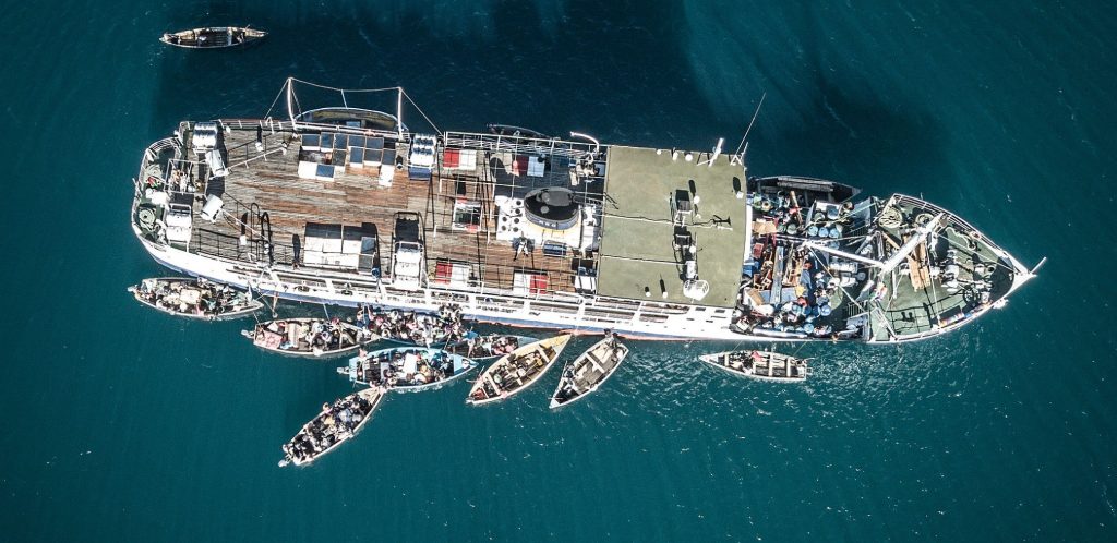 birds eye view of Ilana ferry Malawi surrounded by merchant boats on Malawi Lake which is deep teal in color