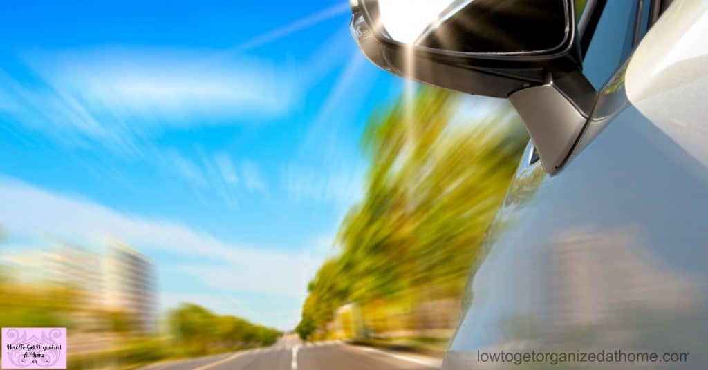 How To Check Your Vehicle For A Road Trip car on the road with motion blur and sunlight in the mirror