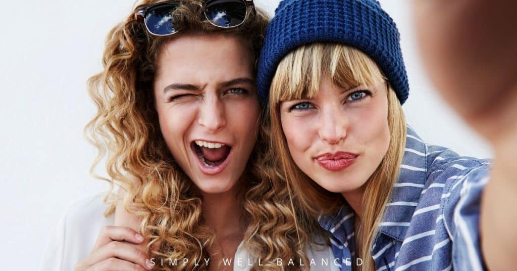 Two female cousins taking a selfie and being silly together.