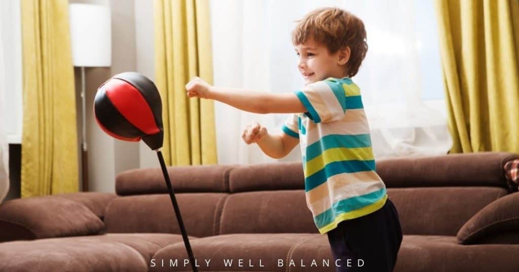 Toddler using a punching bag in the living room