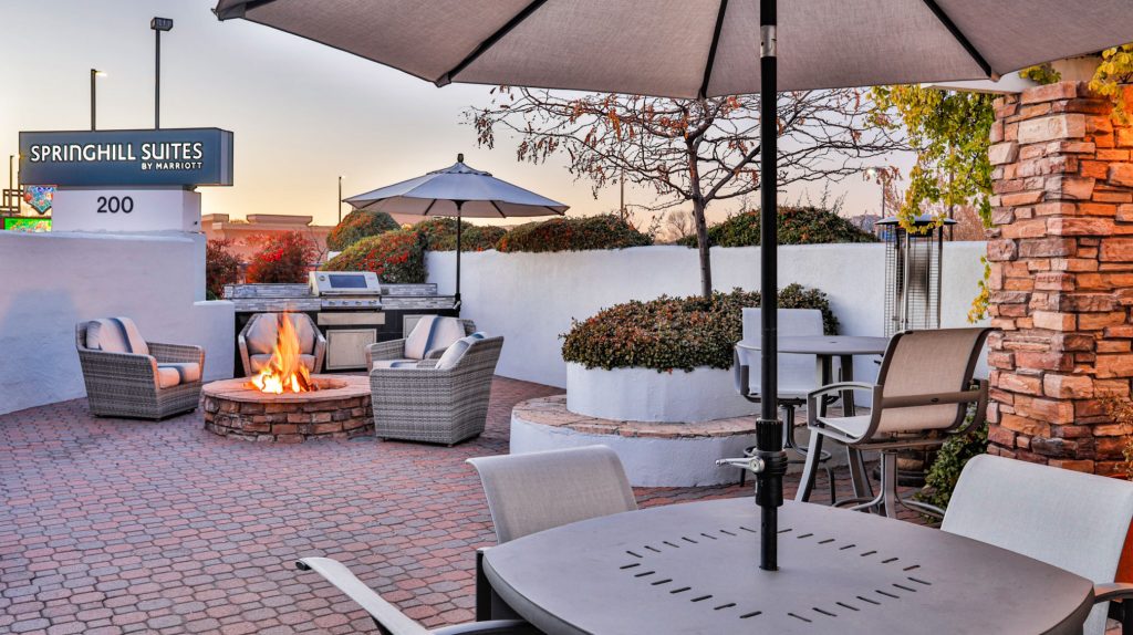 outdoor patio with gas grill, firepit, comfy deep chairs, umbrella tables and tile flooring