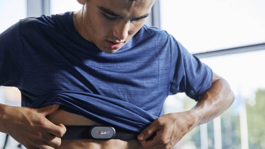 An athlete putting on his heart rate monitor