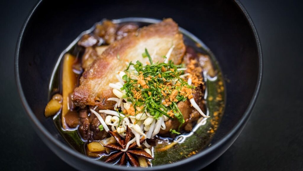 Caramelized palm sugar braised pork shank with star anis, bambo shoots and crispy breast from Cuisine Wat Damnak