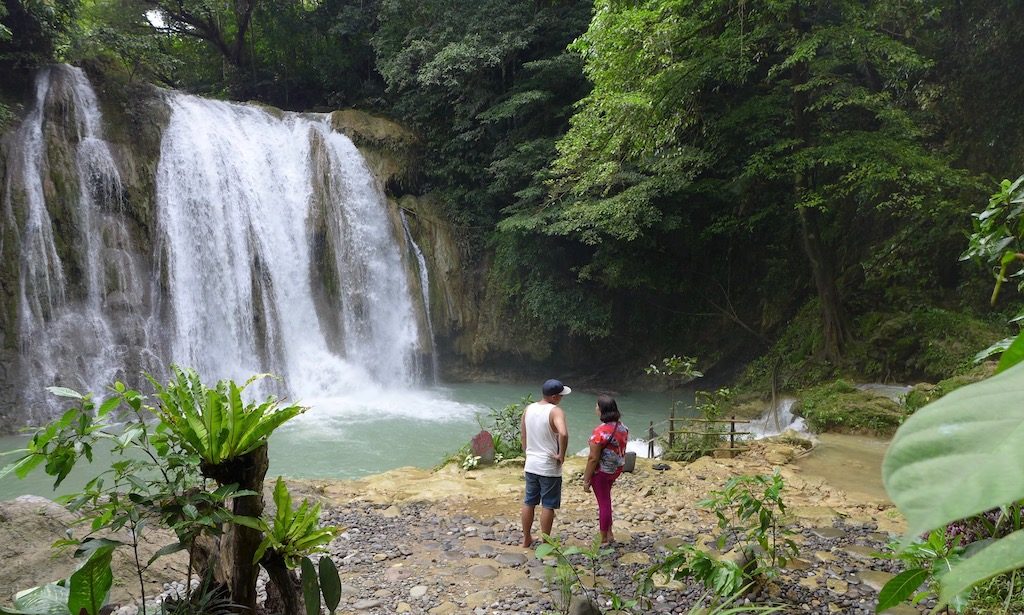 Urlaub auf den Philippinen - Zwei Menschen stehen vor dem Daranak Wasserfall