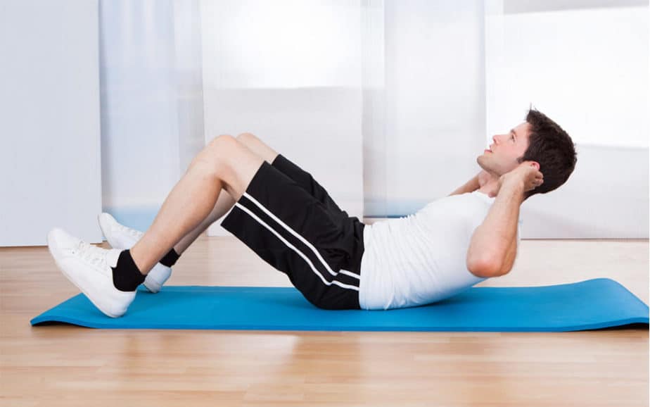 A guy a home training with sit-ups