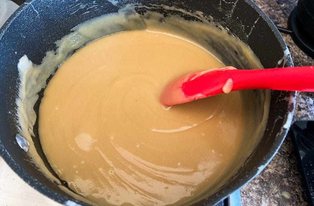 Millionaires Shortbread Caramel Layer being stirred in a pot on the stove
