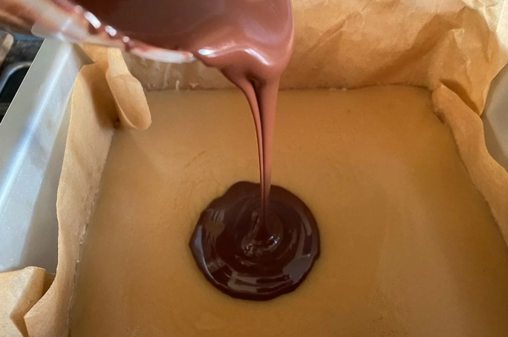Caramel Shortbread Bars - Chocolate Layer being poured onto the Caramel
