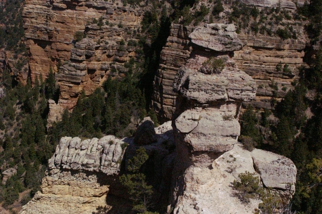 While limestone formation in the shape of a duck sits atop edge of Grand Canyon South Rim