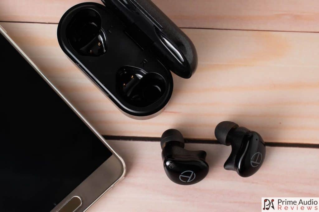 T200 earbuds with charging case and smartphone